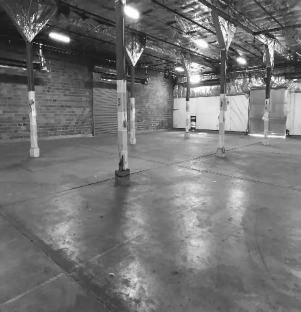A black and white photo of an empty warehouse.
